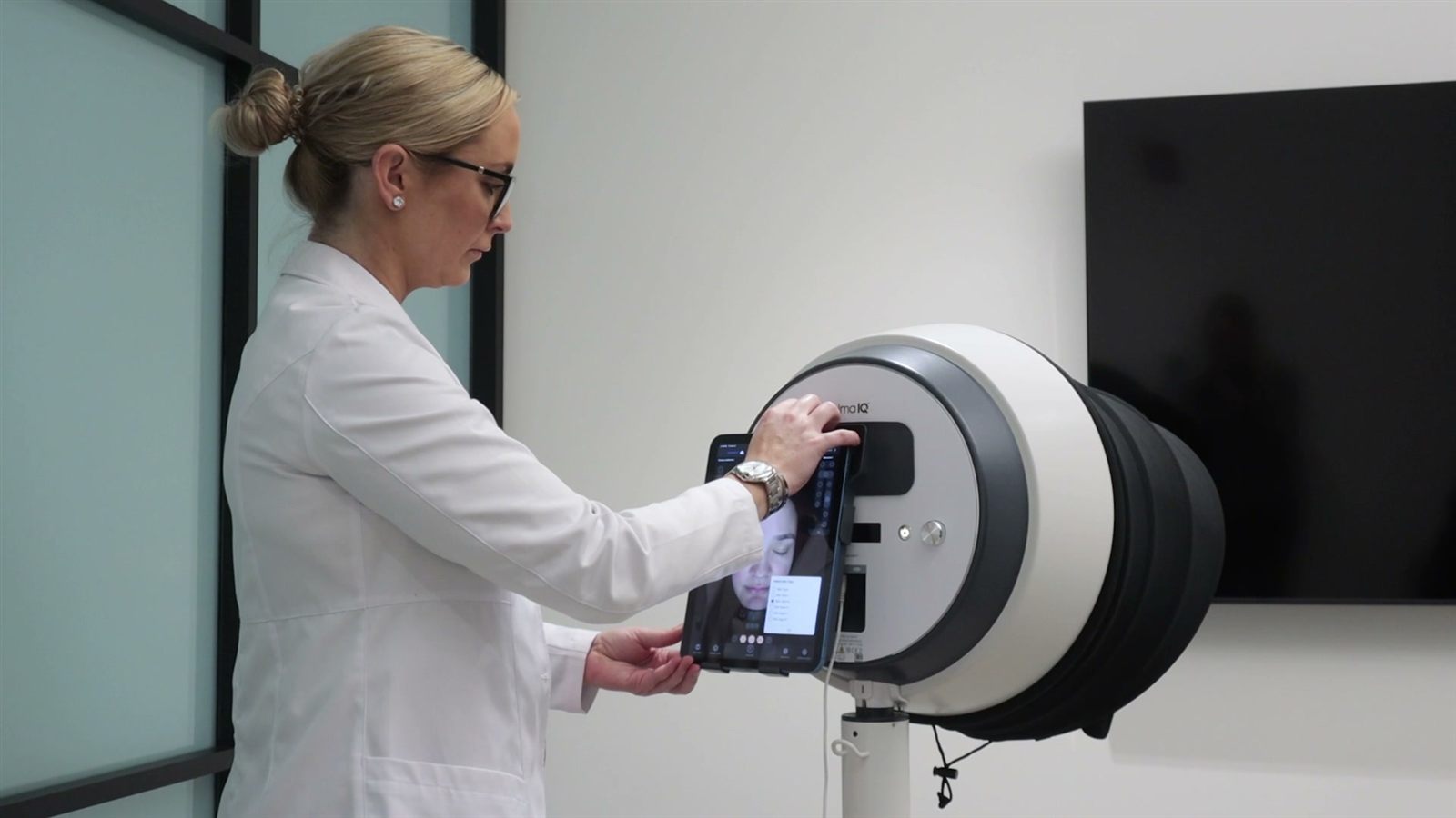 Practitioner operating the Alma IQ AI skin analysis device — the same system used at JuvyDerm Calgary